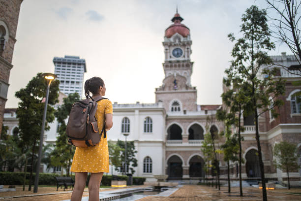 istock Young woman with backpack visiting the Sultan Abdul Samad Building 992221118