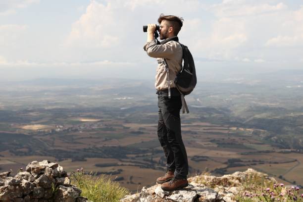 istock CLIMBER LOOKING WITH BINOCULARS FROM THE SUMMIT OF THE MOUNTAIN 992271634