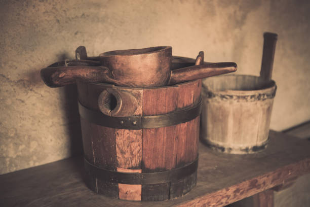 Old wooden barrel and scoop. Wooden barrel, trough, scoop in old country house.
