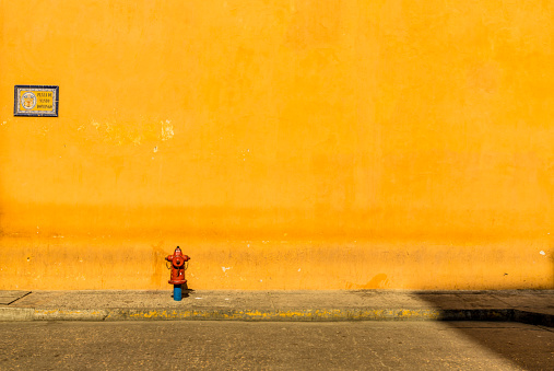 Cartagena, Colombia. march 2018. A view of a fire hydrant against a colorul wall in Cartagena Colombia.