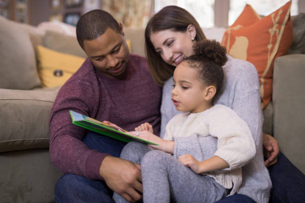 istock Mixed-Race Family Reading Book Aloud Together 992287438