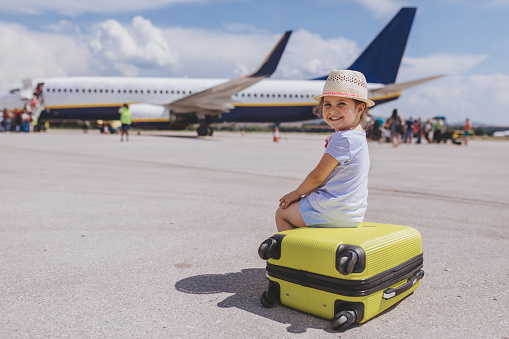 Young and beautiful toddler girl, boarding a plane on a airport.