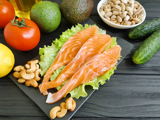 istock fish salmon on a wooden background, tomato, avocado 992291980