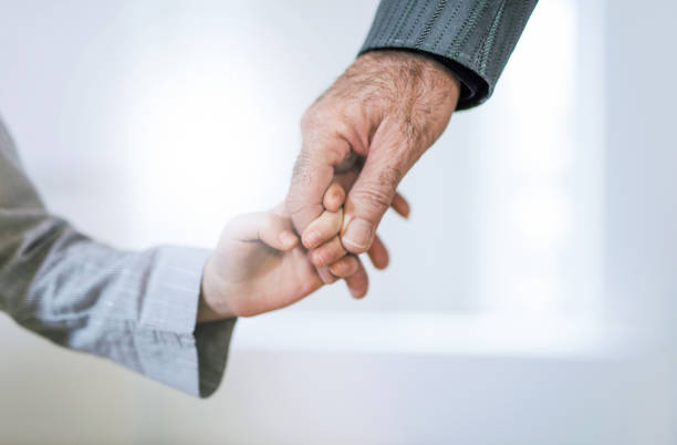 close-up de main de grand-père et sa petite-fille main dans la main. - human hand old senior adult holding hands photos et images de collection