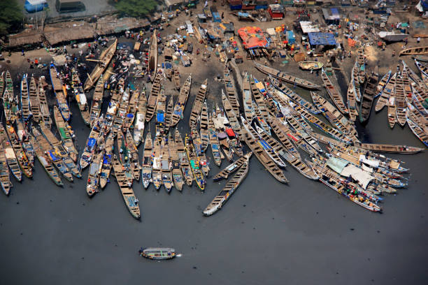 Fisherman's Wharf, Accra, Ghana Fishing boats waiting while fishermen sell the catch of the day on the market. Meanwhile sharks and other catch of the day get offloaded from the boats (top left corner of the picture). shark photos stock pictures, royalty-free photos & images