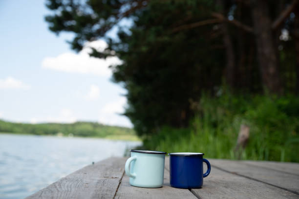 istock two metal cups with tea. river on background. summer time concept 992303944