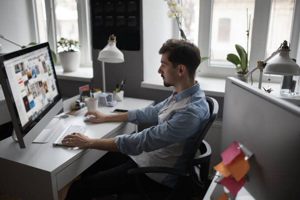 istock Young intelligent bearded man working at modern loft studio-offi 992311066