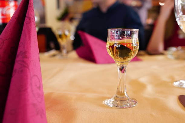 Fruit Brandy Glass Fruit brandy or schnapps in stemmed glass on a restaurant table. serbian raki stock pictures, royalty-free photos & images