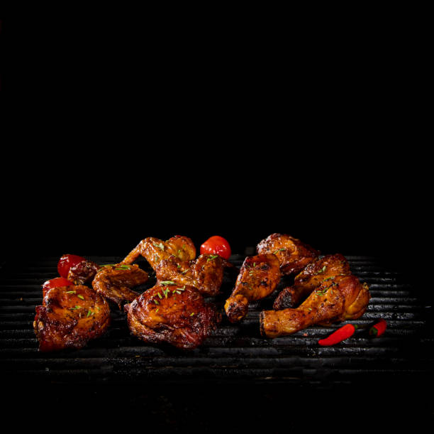 istock Chicken legs and wings on the grill with flames 992315930