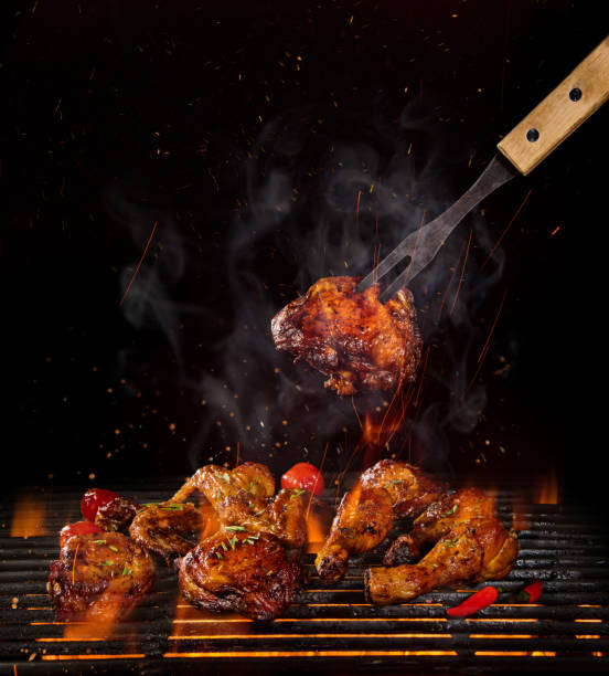 istock Chicken legs and wings on the grill with flames 992316548