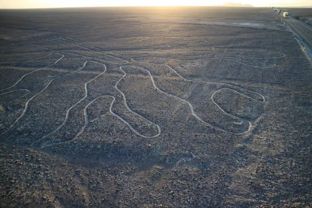 The famous large ancient geoglyphs Nazca lines called Arbol (tree), view from observation tower in Nazca desert of Peru