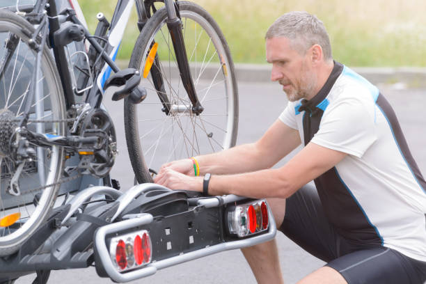 hombre carga de bicicletas en el portabicicletas - bicycle rack fotografías e imágenes de stock
