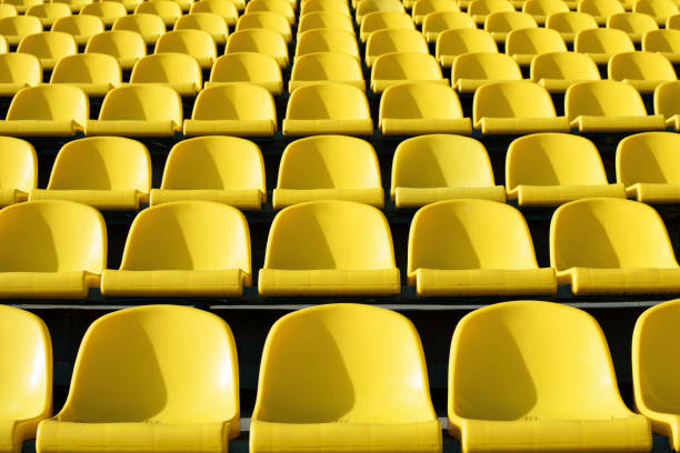 asientos vacíos plástico amarillo, en el estadio, campo de deportes de la puerta abierta. - bleachers stadium seat empty fotografías e imágenes de stock