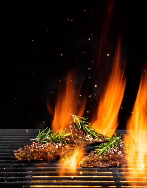istock Beef steaks being grilled, isolated on black 992343796