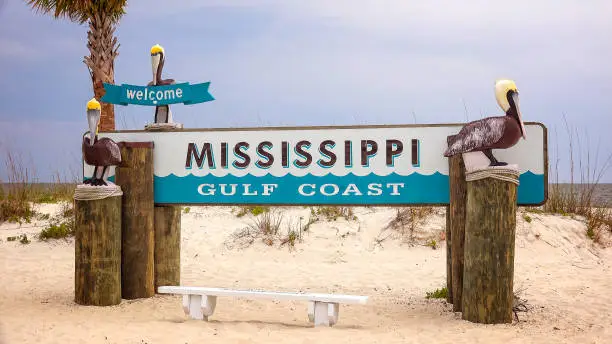 Welcome to Mississippi Gulf Coast sign on sandy beach in Gulfport