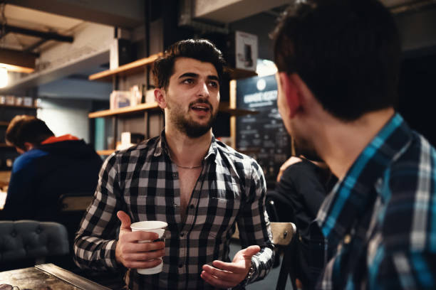 istock Two Friends Drinking Coffee and Socialising in a Cafe 992375622