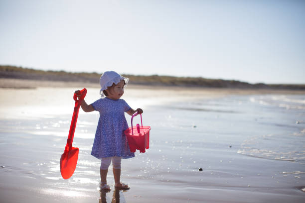 istock baby girl playing at summer beach 992382900