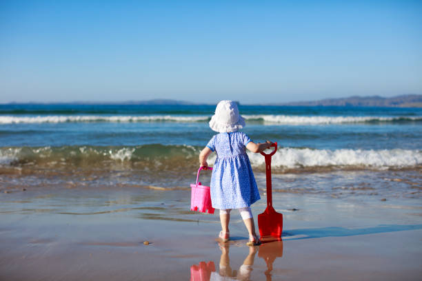 istock baby girl playing at summer beach 992383194