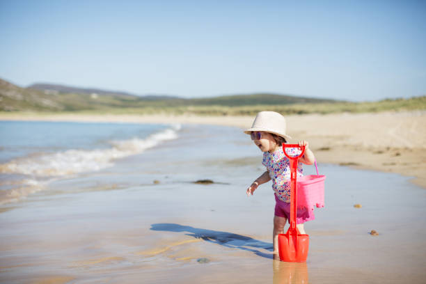 istock baby girl playing at summer beach 992383270