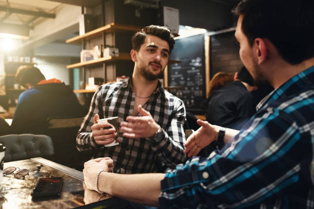 istock Two Friends Drinking Coffee and Socialising in a Cafe 992387348