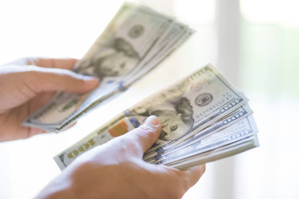istock Soft focus on woman hands counting us dollar bills. 992396630