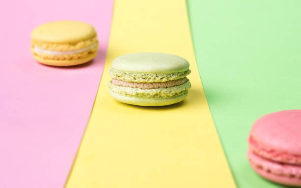 istock Yellow, green and pink macaroons on colorful background 992411520