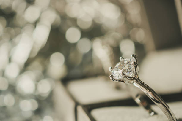 istock luxury engagement Diamond ring in jewelry gift box with bokeh light background 992442182