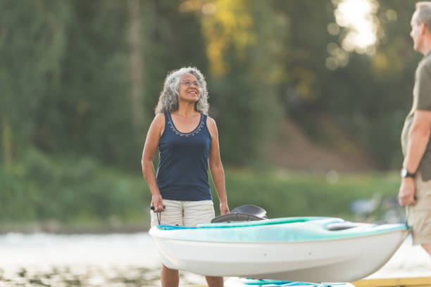 istock Senior couple stands on dock and gets ready to kayak 992451570