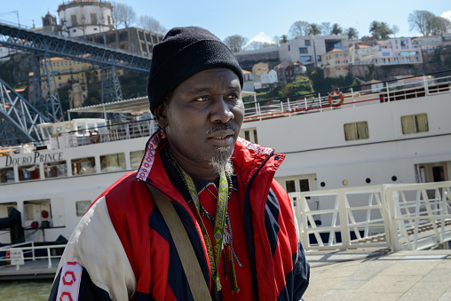 Porto, Portugal - March 29, 2014: African immigrant is seen in the Ribeira, traditional and tourist point of the city of Oporto.