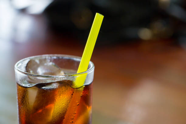 glass of cola with ice with copy-space in composition.Ice soda glass.refresh drink.Cola with crushed ice and straw in glass on white background.