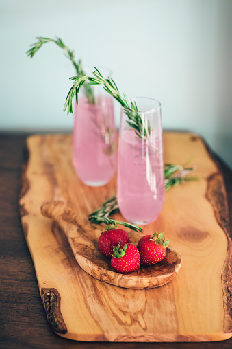 Strawberry cocktails garnished with rosemary sprigs.