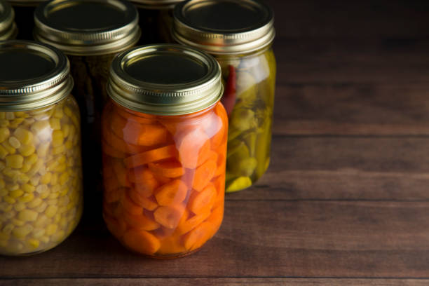 istock Various Types of Canned Vegetables on a Wooden Table in a Dark Environment 992511720