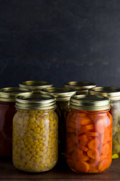 istock Various Types of Canned Vegetables on a Wooden Table in a Dark Environment 992516528