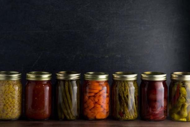 istock Various Types of Canned Vegetables on a Wooden Table in a Dark Environment 992516622