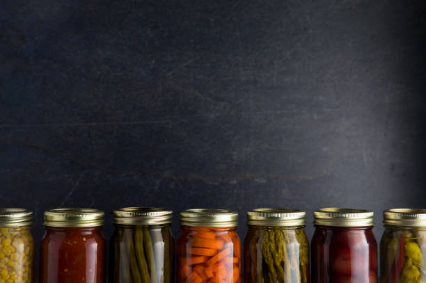 istock Various Types of Canned Vegetables on a Wooden Table in a Dark Environment 992516662