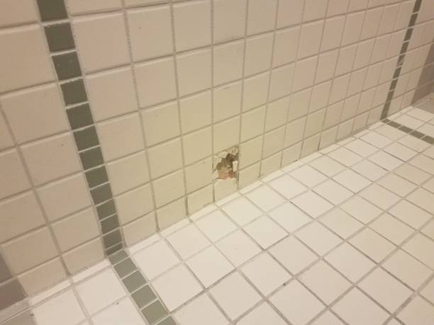 istock a hole in the white and green bathroom wall tiles 992539776
