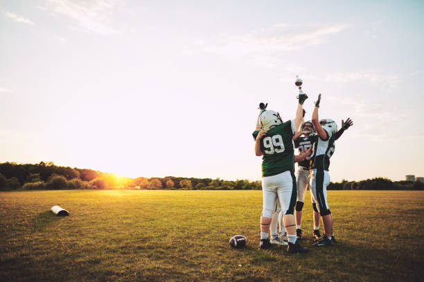 fußball-nationalmannschaft feiert mit ihrer trophäe auf einem feld - mannschaftssport stock-fotos und bilder
