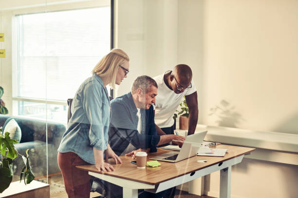 istock Diverse businesspeople working together on a laptop at a desk 992567900