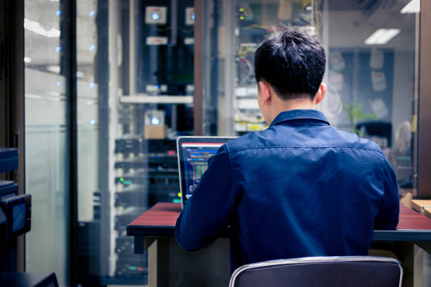 technicy korzystający z laptopa podczas analizowania serwera w serwerowni - computer programmer network server data center zdjęcia i obrazy z banku zdjęć