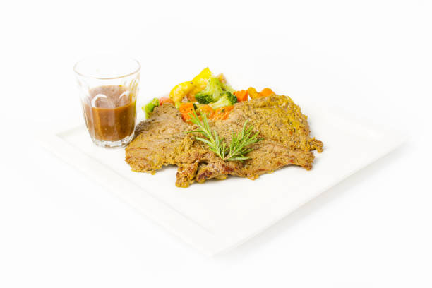 istock Pork steak grilled with black peper sauce and mixed vegetable, rosemary on white background 992576734