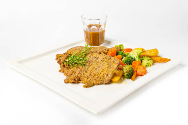 istock Pork steak grilled with black peper sauce and mixed vegetable, rosemary on white background 992576736