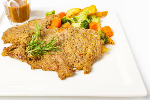 istock Pork steak grilled with black peper sauce and mixed vegetable, rosemary on white background 992576738
