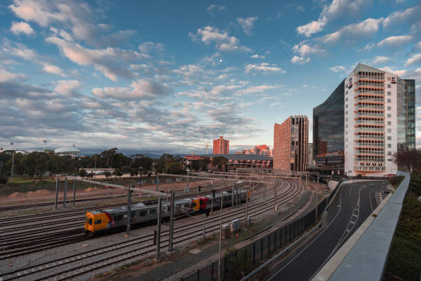 Adelaide, South Australia / Australia - June 24 2018: Train leaves the station in Adelaide city with University of Adelaide building visible in the background