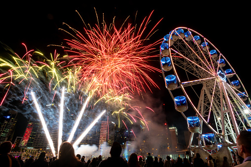 Fireworks exploding behind a Ferris wheel