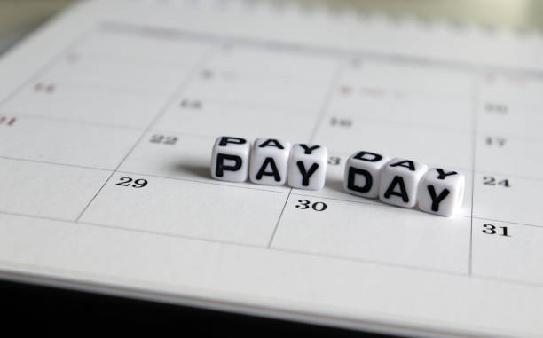 A white cube arranged in the word ’PAY DAY ' on the calendar. stock photo
