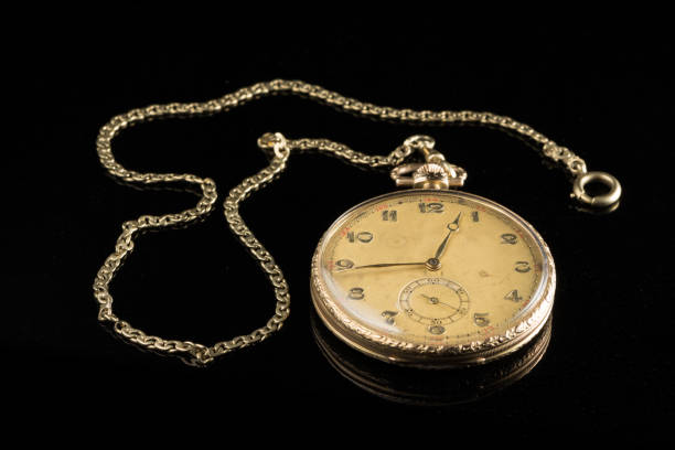 istock Golden pocket watch on a black reflective surface 992606854