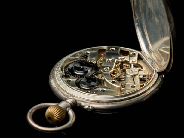 istock Old pocket watch on a black reflective surface, back side lid open 992607950