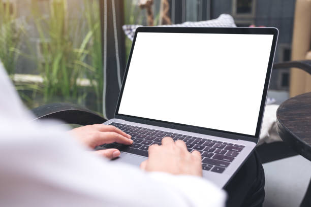 istock Mockup image of a woman using and typing on laptop with blank white desktop screen while sitting on a chair 992608338