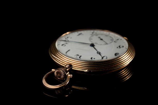 istock Golden pocket watch on a black reflective surface 992611292