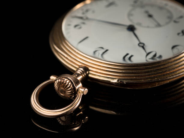 istock Golden pocket watch on a black reflective surface 992612648